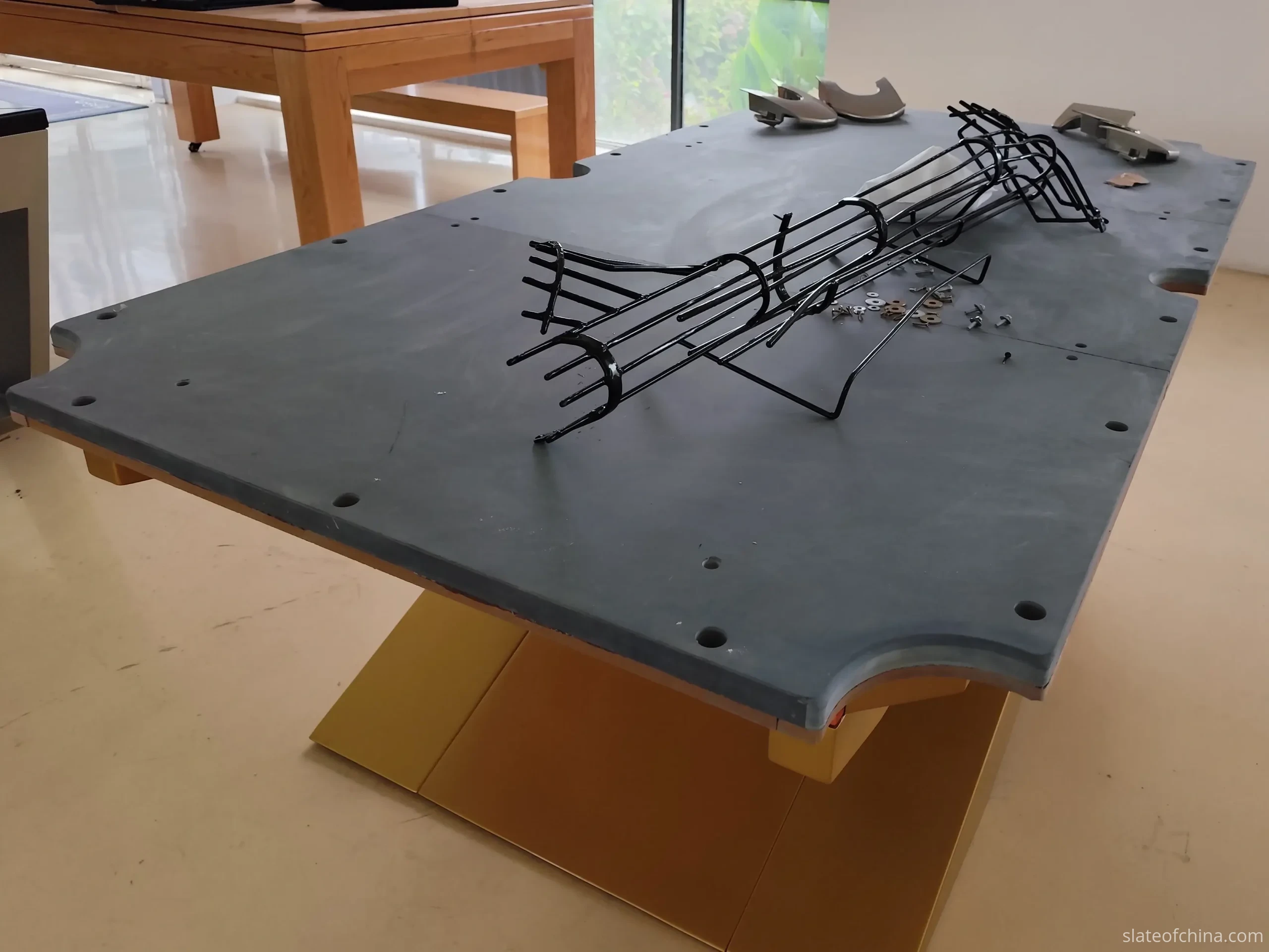 Three-piece slate set on frame support structure Three-piece billiard slate set resting on a table frame, showing the relationship between slate panels and support beams